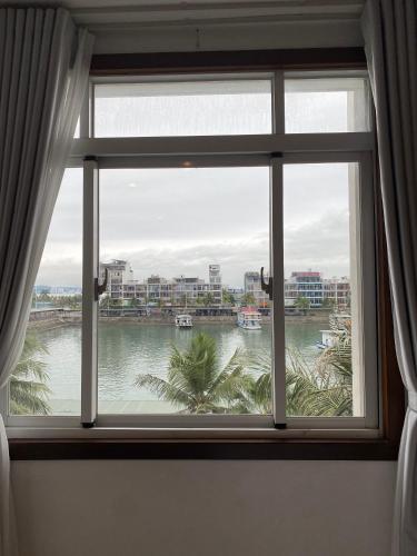 a window with a view of a river at SOCHU HOUSE- Tuần Châu Homestay & Coffee in Ha Long