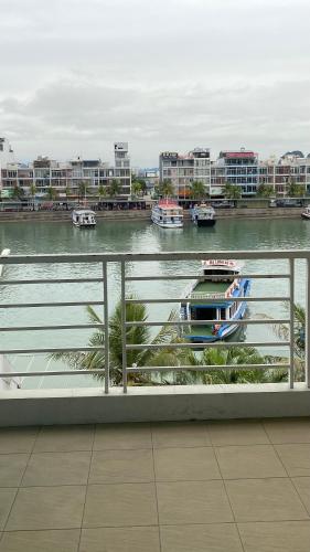 a boat on a river with buildings in the background at SOCHU HOUSE- Tuần Châu Homestay & Coffee in Ha Long