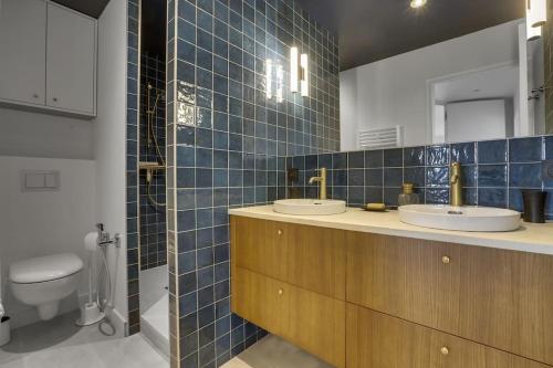 une salle de bain avec deux lavabos et un WC dans l'établissement Auteuil - Appartement lumineux rénové, à Biarritz