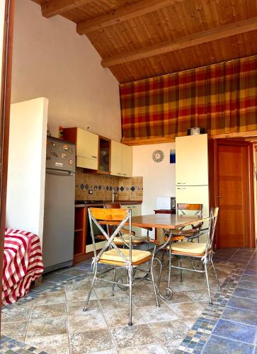 eine Küche mit einem Tisch und Stühlen sowie einem Kühlschrank in der Unterkunft Casa Melina in Marina di Ragusa