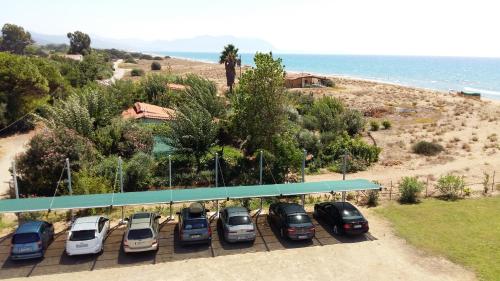 a row of cars parked in a parking lot next to the ocean at Ostria Hotel Kakovatos Beach in Zakharo