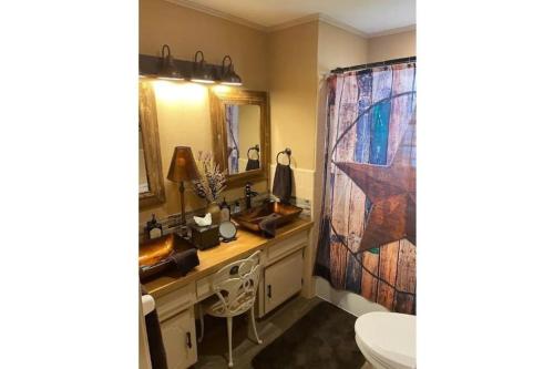 baño con 2 lavabos y cortina de ducha en StockYards! Walk 3 Blocks-Ranch House sleeps 8, en Fort Worth