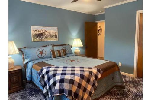 a bedroom with a bed with a checkered blanket on it at StockYards! Walk 3 Blocks-Ranch House sleeps 8 in Fort Worth