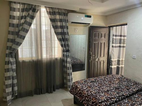a bedroom with a bed and a window with curtains at 2 Bedroom and a kitchen. in Abuja