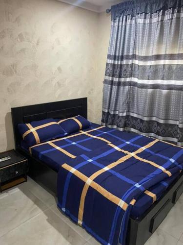 a bedroom with a blue bed with a window at 2 Bedroom and a kitchen. in Abuja