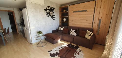 a living room with a brown couch and a refrigerator at Apartment Beach Front Canet in Canet de Mar
