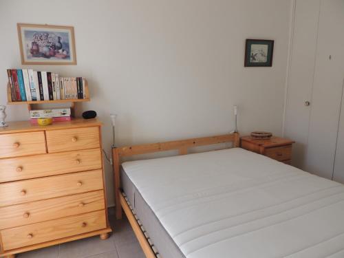 Un dormitorio con una cama y una cómoda de madera. en Petit Paradis a Saint Mandrier 1 chambre plage à 4 mn CLIM Parking Wifi, en Saint-Mandrier-sur-Mer