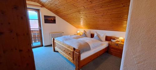 um quarto com uma cama grande e um tecto em madeira em Gästehaus Krumbacher em Bolsterlang