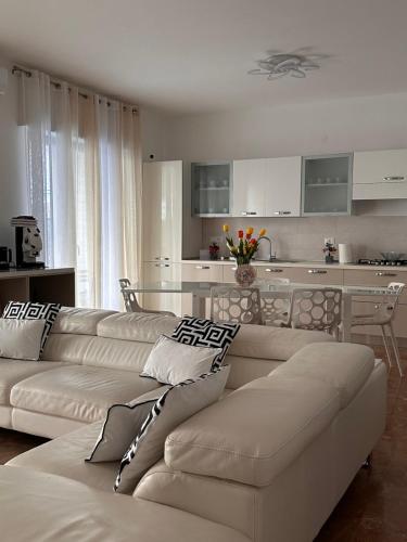 sala de estar con 2 sofás blancos y cocina en BnB Nuova Vita, en Paola