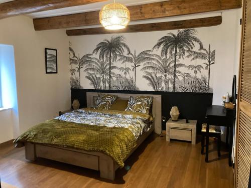 um quarto com uma cama com palmeiras na parede em La maisonnée Auvergnate em Auzelles