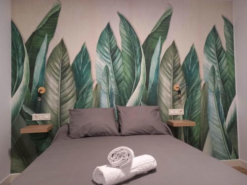 1 dormitorio con 1 cama con un mural de hojas en Casa Fénix en el centro de Andalucía en Roda de Andulucia