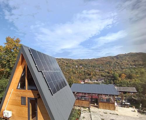 a house with solar panels on the roof of it at CARPATINA Ruustic House in Runcu