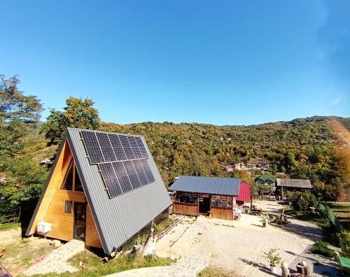 a house with solar panels on the roof at CARPATINA Rustic House in Runcu