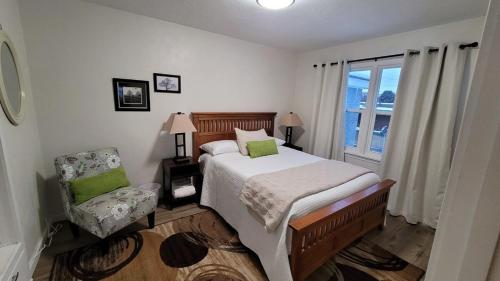 a bedroom with a bed and a chair and a window at Pet Friendly 5 Bed Home with Waffle Breakfast in Ogden