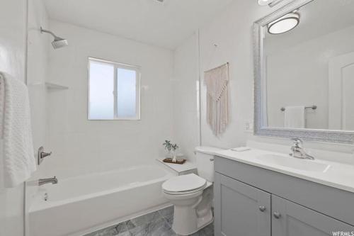 a white bathroom with a toilet and a sink at Pet Friendly 5 Bed Home with Waffle Breakfast in Ogden