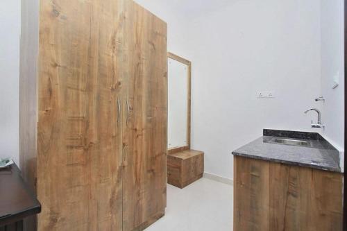 uma casa de banho com uma parede de madeira ao lado de um lavatório em Hotel Royal Residence HSR Layout em Bangalore