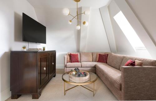 a living room with a couch and a tv at Fairmont Le Chateau Frontenac in Quebec City