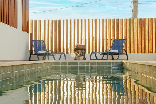 two chairs and a swimming pool in a house at Casa Paraíso Lençóis in Santo Amaro