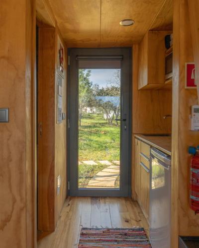 a kitchen with a door leading to a yard at Refugio do Carrascal in Tomar