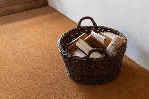 a basket full of wood sitting on the floor at Der Turm Leiben Apartments in Leiben