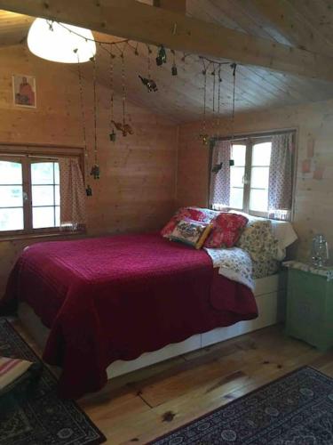 une chambre avec un lit dans une cabane en rondins dans l'établissement Le Paradis caché : Chalet Shangri-La, à Villennes-sur-Seine