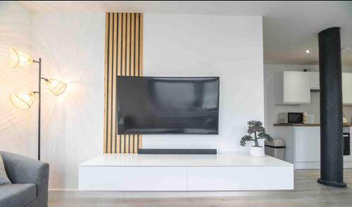 uma sala de estar com televisão num centro de entretenimento branco em Conditioning House - Suite 1 em Bradford