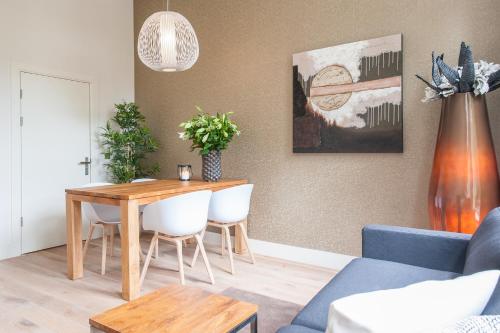 a living room with a table and a blue couch at Museumpark Apartments in Rotterdam
