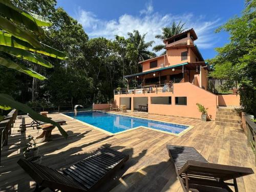 a house with a swimming pool in front of a house at Casa Amadou com grande piscina em Boipeba in Ilha de Boipeba