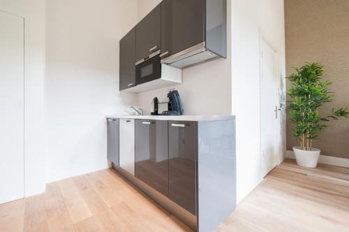 a kitchen with a sink and a microwave at Museumpark Apartments in Rotterdam