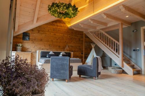 a living room with a staircase and a couch and chairs at Agriturismo Rini in Bormio