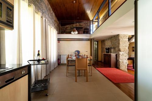a kitchen with a table and a dining room at Casa de Silvares Fafe - Moradia Premium com piscina by House and People in Regadas