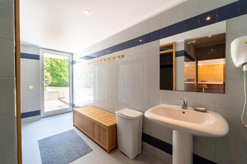 La salle de bains est pourvue d'un lavabo et d'un miroir. dans l'établissement Casa de Silvares Fafe - Moradia Premium com piscina by House and People, à Regadas