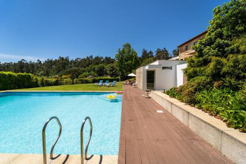 a swimming pool with two metal chairs next to a house at Casa de Silvares Fafe - Moradia Premium com piscina by House and People in Regadas