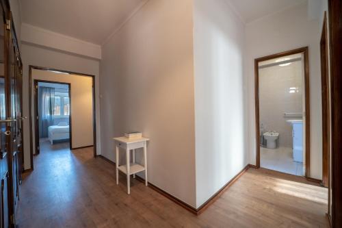 um corredor com uma parede branca, uma mesa e uma casa de banho em Elísio de Moura - T5 ideal para familias - Braga em Braga