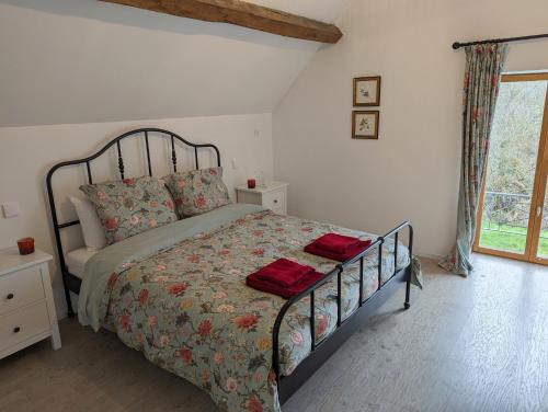 ein Schlafzimmer mit einem Bett mit roten Handtüchern darauf in der Unterkunft House by the River in Morlac