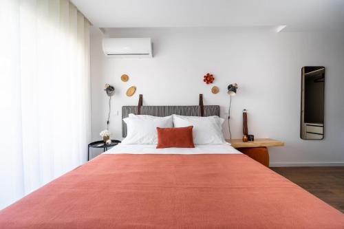 a bedroom with a large bed with a red blanket at João da Ponte - T1 Altice Forum Braga by House and People in Braga