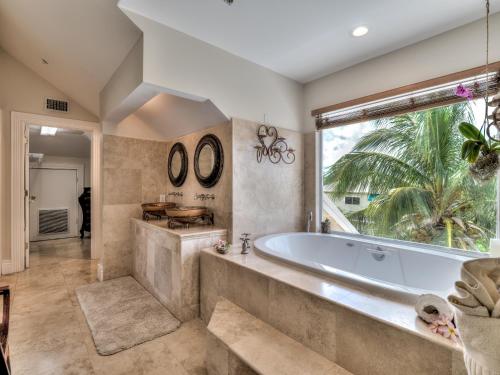 a large bathroom with a tub and a large window at Sol Mar-Oceanfront Beachhouse in Captiva