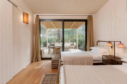 a bedroom with two beds and a dining room with a table at Retreat & Glamping Terre di Sacra in Toscana in Capalbio