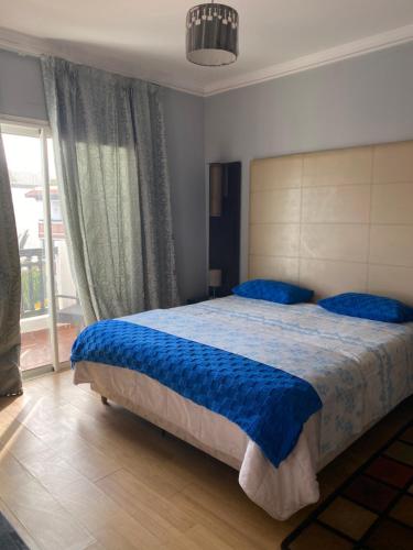 アガディールにあるluxe appartement marinaのベッドルーム1室(大型ベッド1台、青いシーツ付)