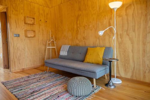 a living room with a blue couch and a lamp at Refugio do Carrascal in Tomar