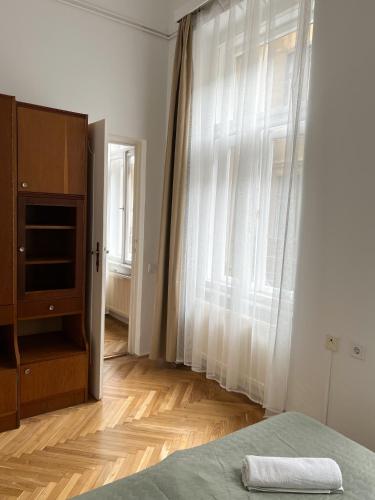 una camera con un letto e una grande finestra di Home in the centre of Budapest a Budapest