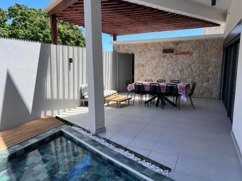 um pátio com uma mesa e cadeiras e uma piscina em MSLodge em Kani Keli