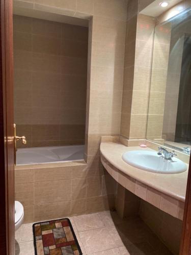 y baño con lavabo, bañera y aseo. en luxe appartement marina en Agadir