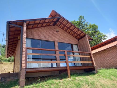Casa con ventana grande y terraza de madera en Vivendas Canaã, en Espera Feliz