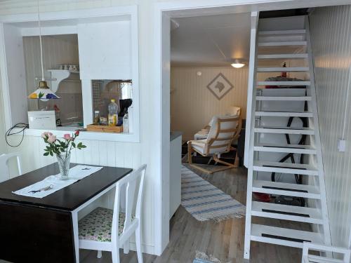 a kitchen and dining room with a staircase and a table at Hyttingsfabodstugor in Borlänge