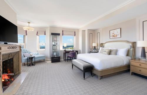a bedroom with a bed and a living room with a fireplace at Fairmont Le Chateau Frontenac in Quebec City