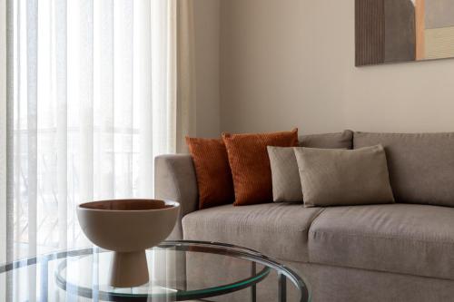 a living room with a couch and a glass table at CLOCK Central Stay in Xanthi