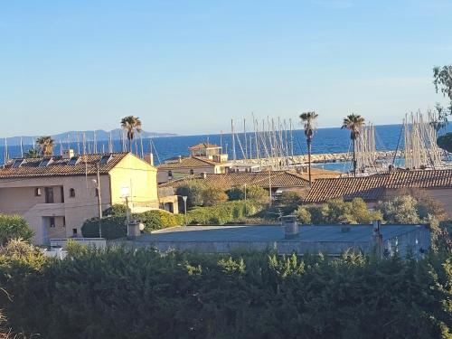 une vue d'une ville avec des palmiers et l'océan dans l'établissement studio belle vue, à La Londe-les-Maures
