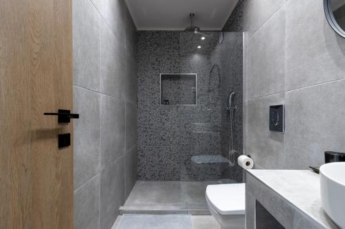 a bathroom with a shower and a toilet and a sink at CLOCK Central Stay in Xanthi