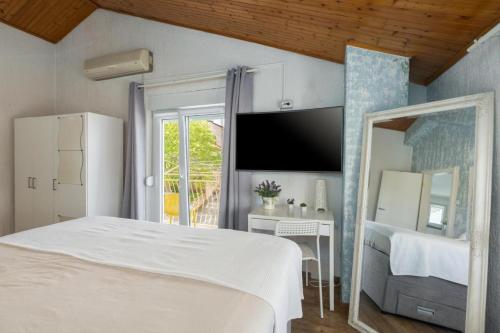 a bedroom with a white bed and a television at Evan Seaview in Funtana